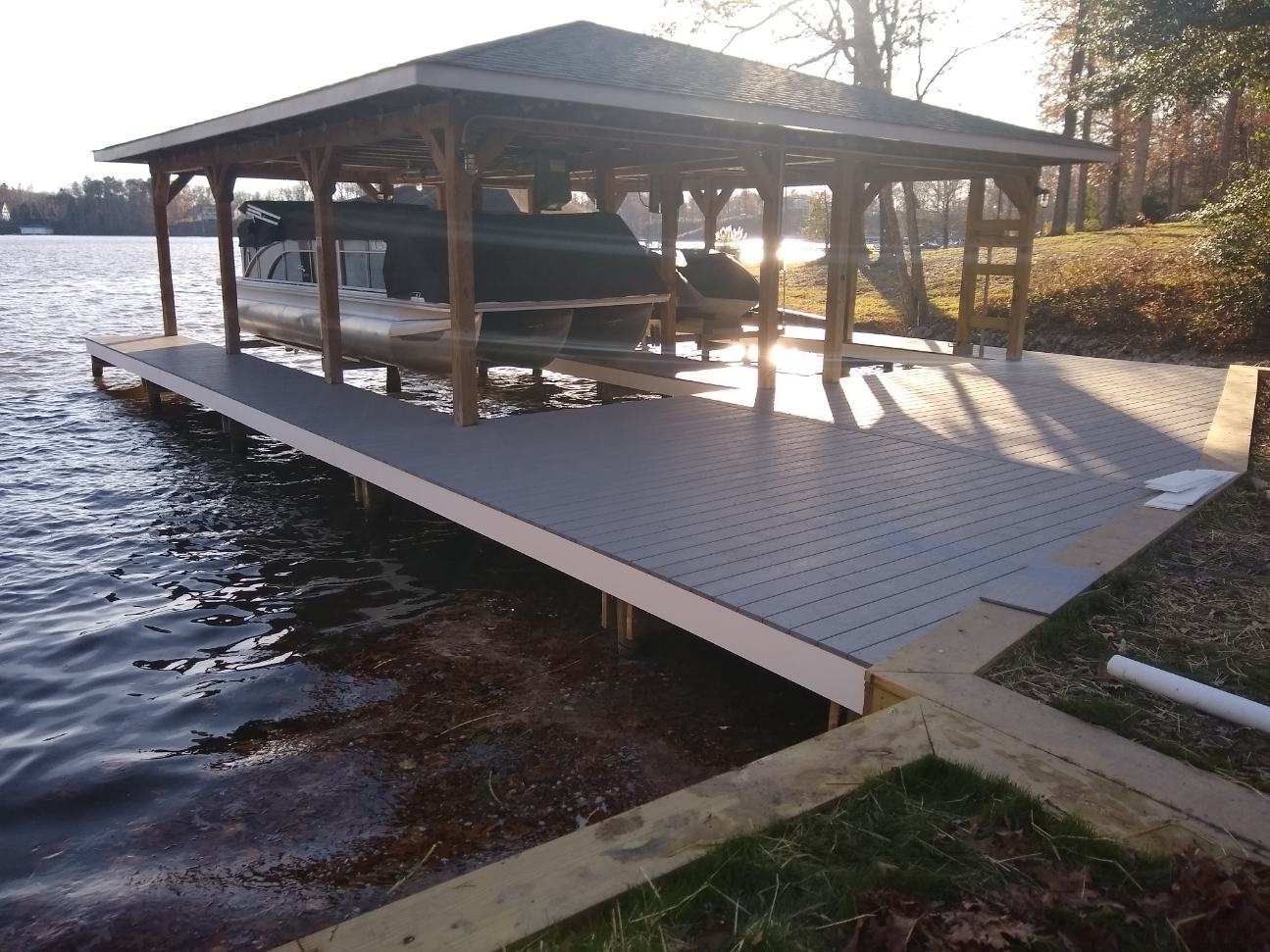 A boat is under a wooden structure on a dock