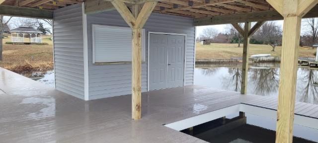 There is a boat in the water under a covered dock.