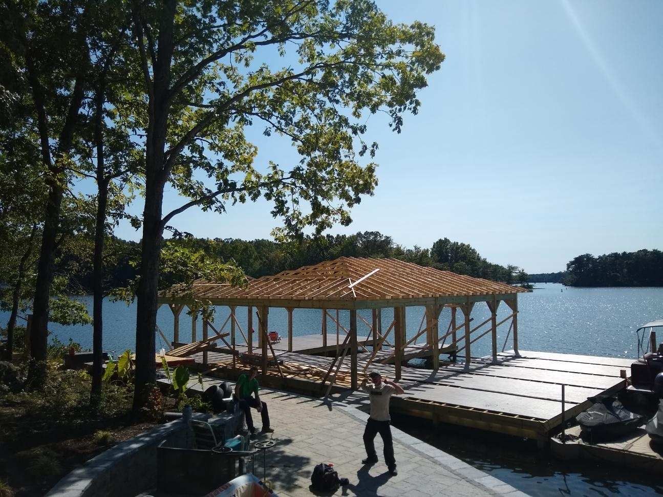 A wooden structure is being built on the shore of a lake