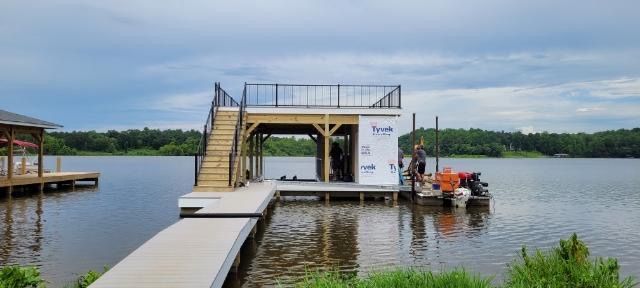 A boat is docked at a dock in the middle of a lake.
