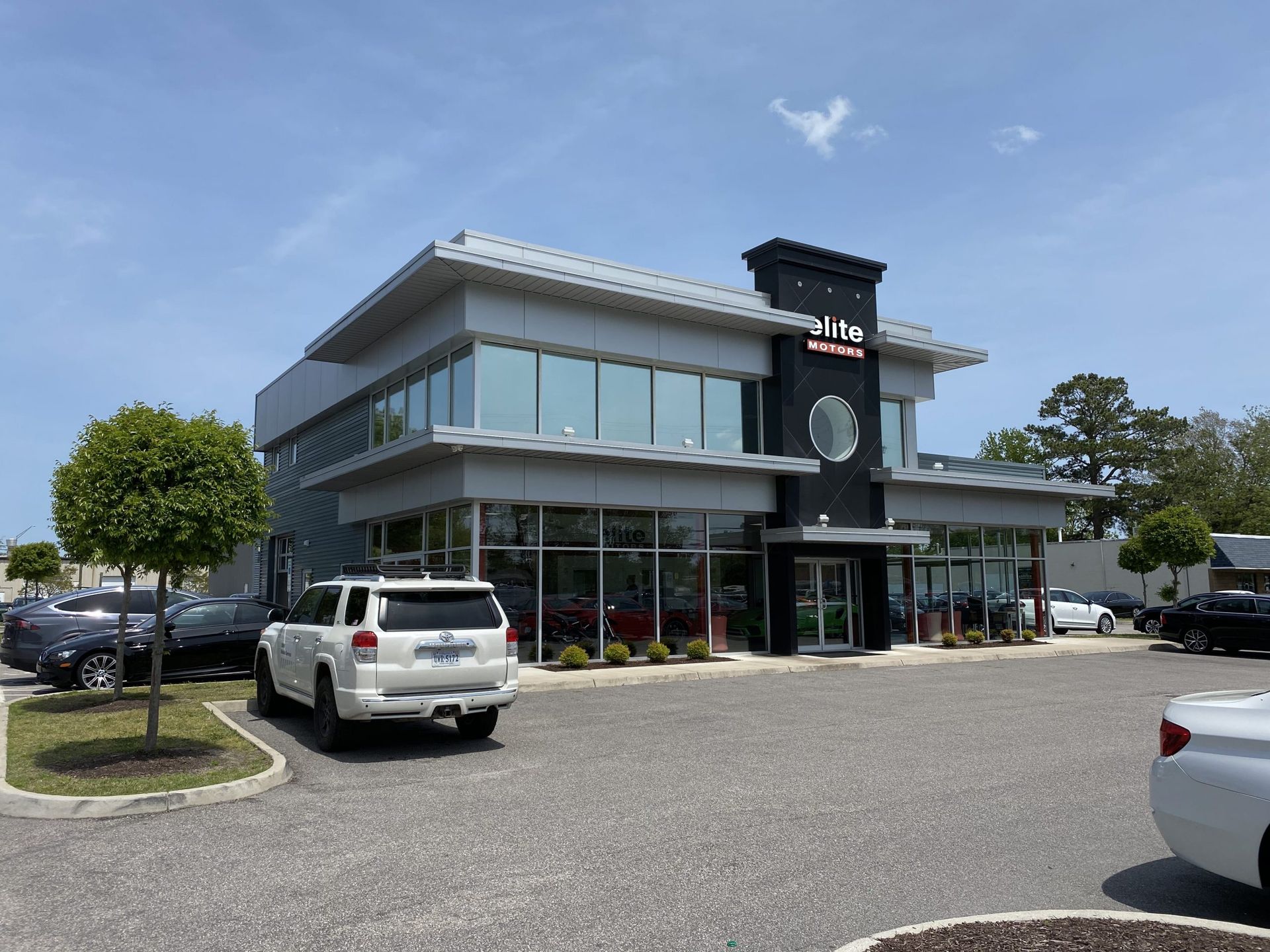 A white suv is parked in front of a large building.