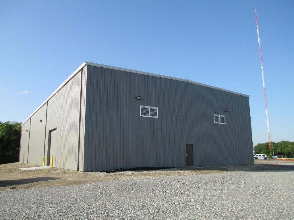 A large gray building with a tower in the background