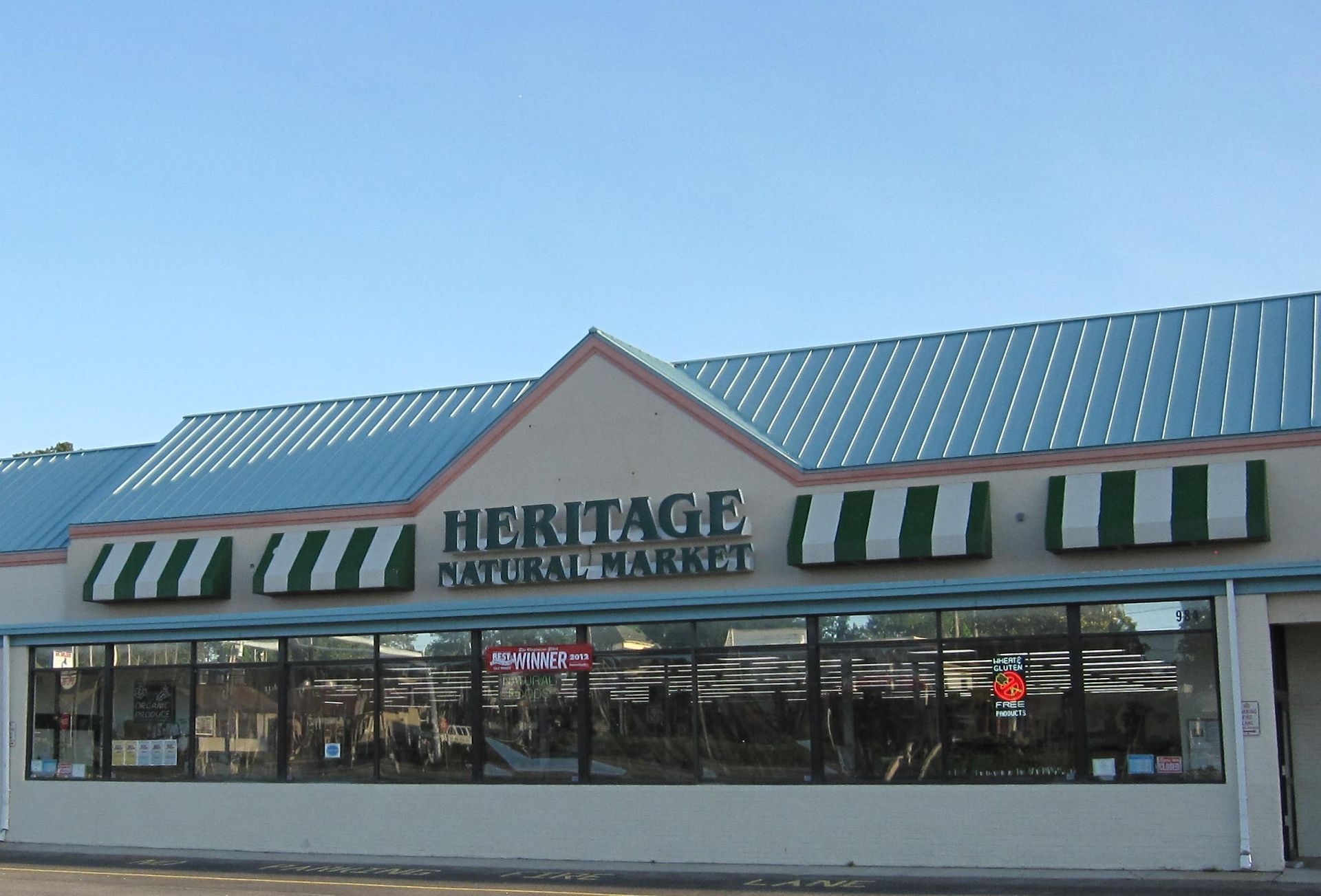 Heritage natural market has a blue roof and green and white awnings