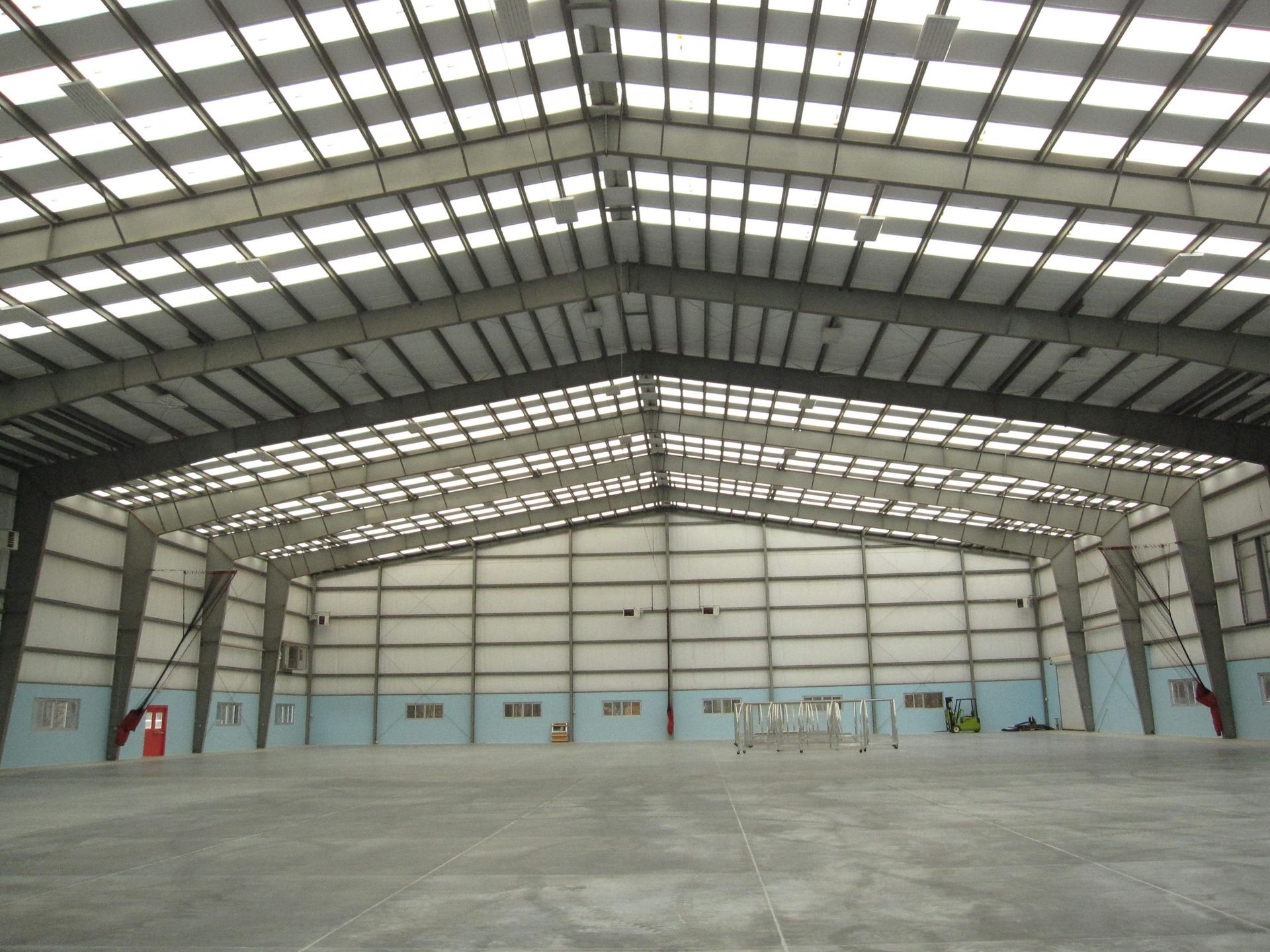 An empty warehouse with a roof that has a lot of windows
