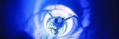 Blue-lit turbine or fan blades spinning in a circular industrial close-up