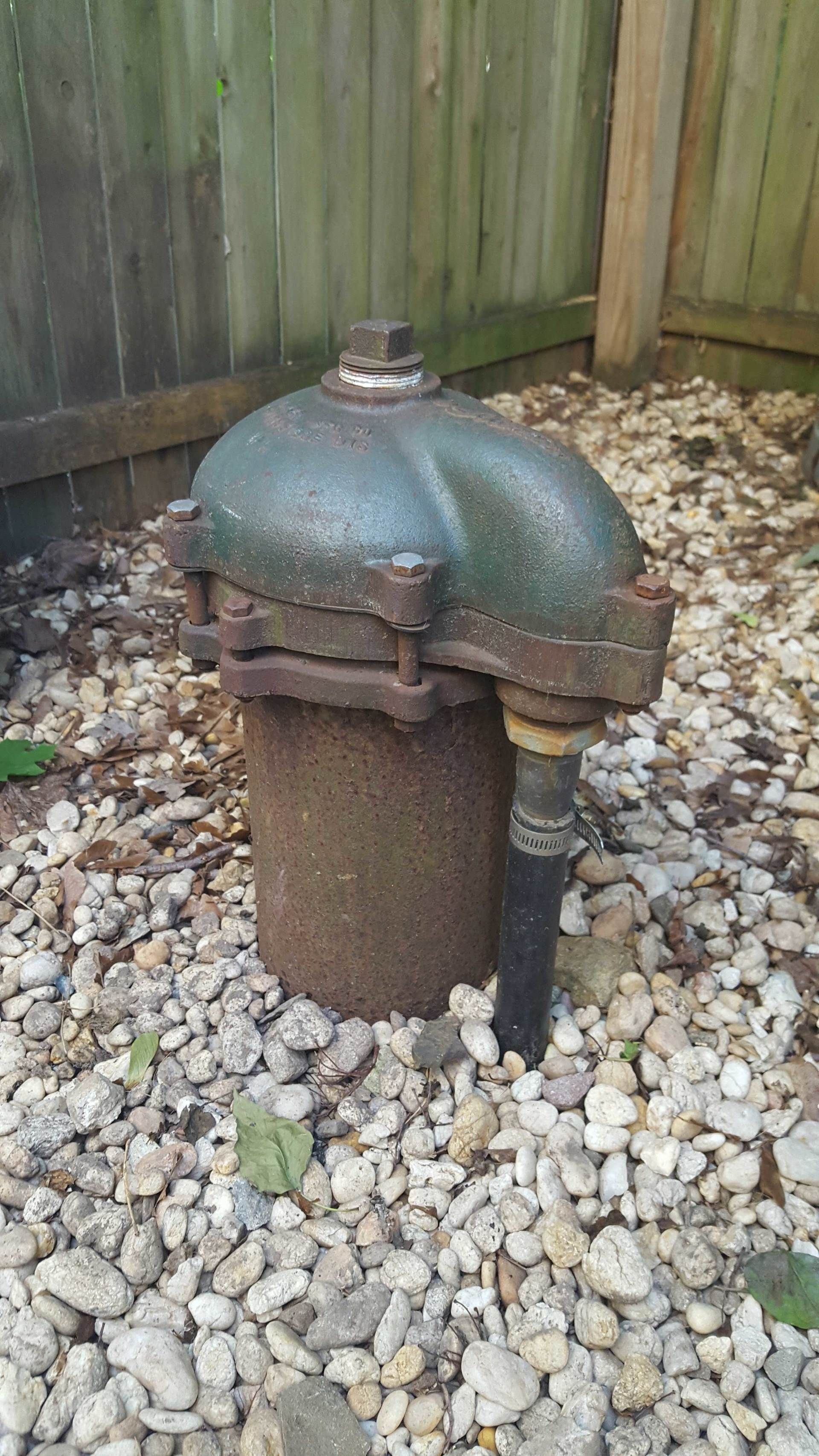 A rusty fire hydrant is sitting on top of a pile of rocks.
