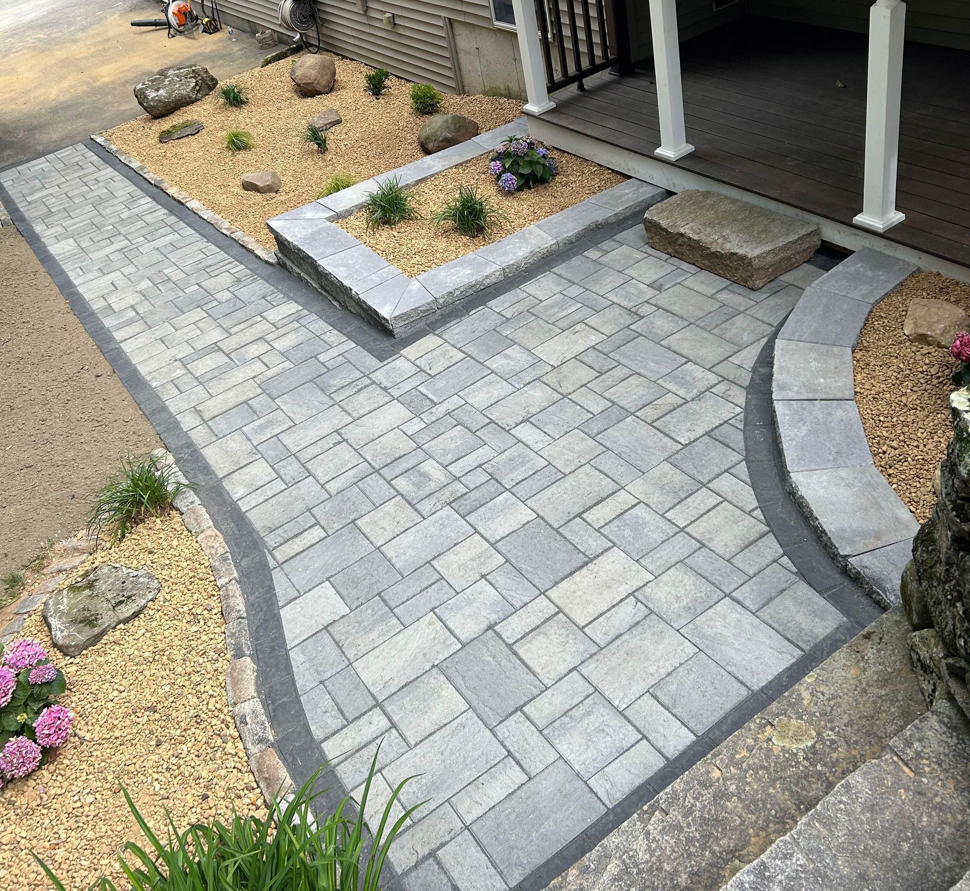 Stone retaining wall with a landscaped garden bed and steps.