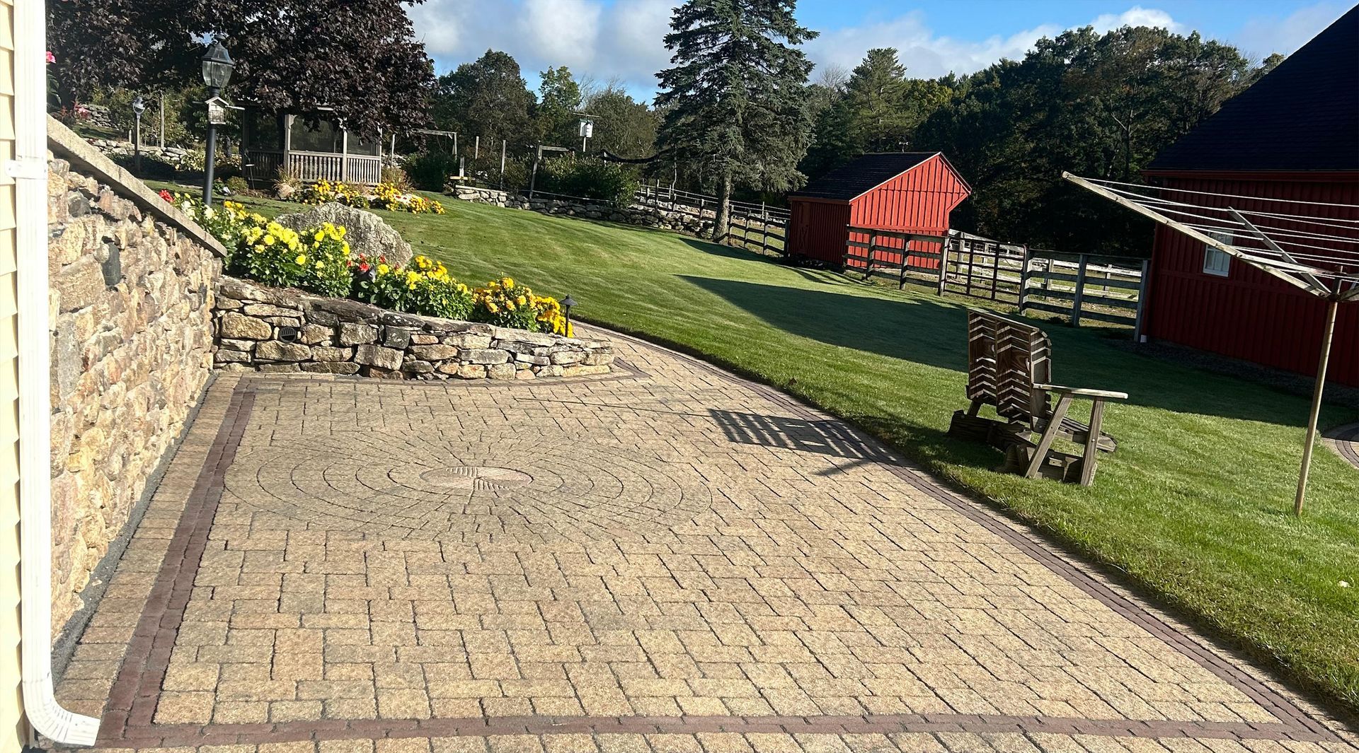 Stone staircase leading up to a house with a garage door, surrounded by lush greenery.