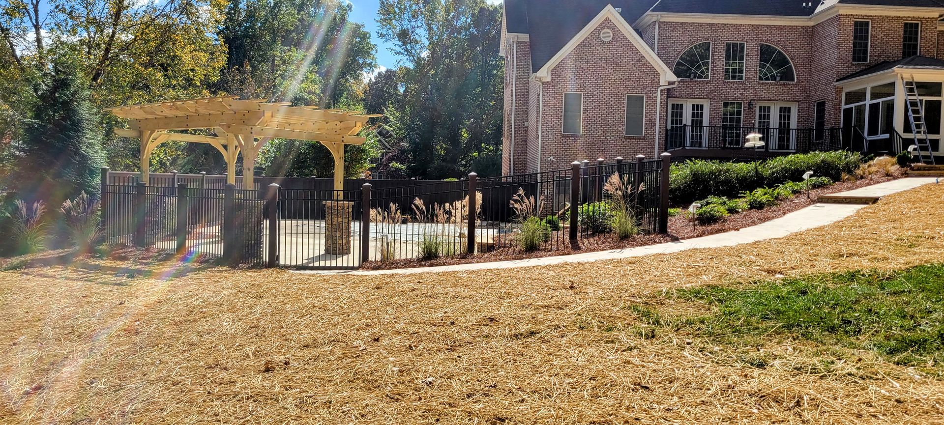 A large house with a pergola and a walkway in front of it.