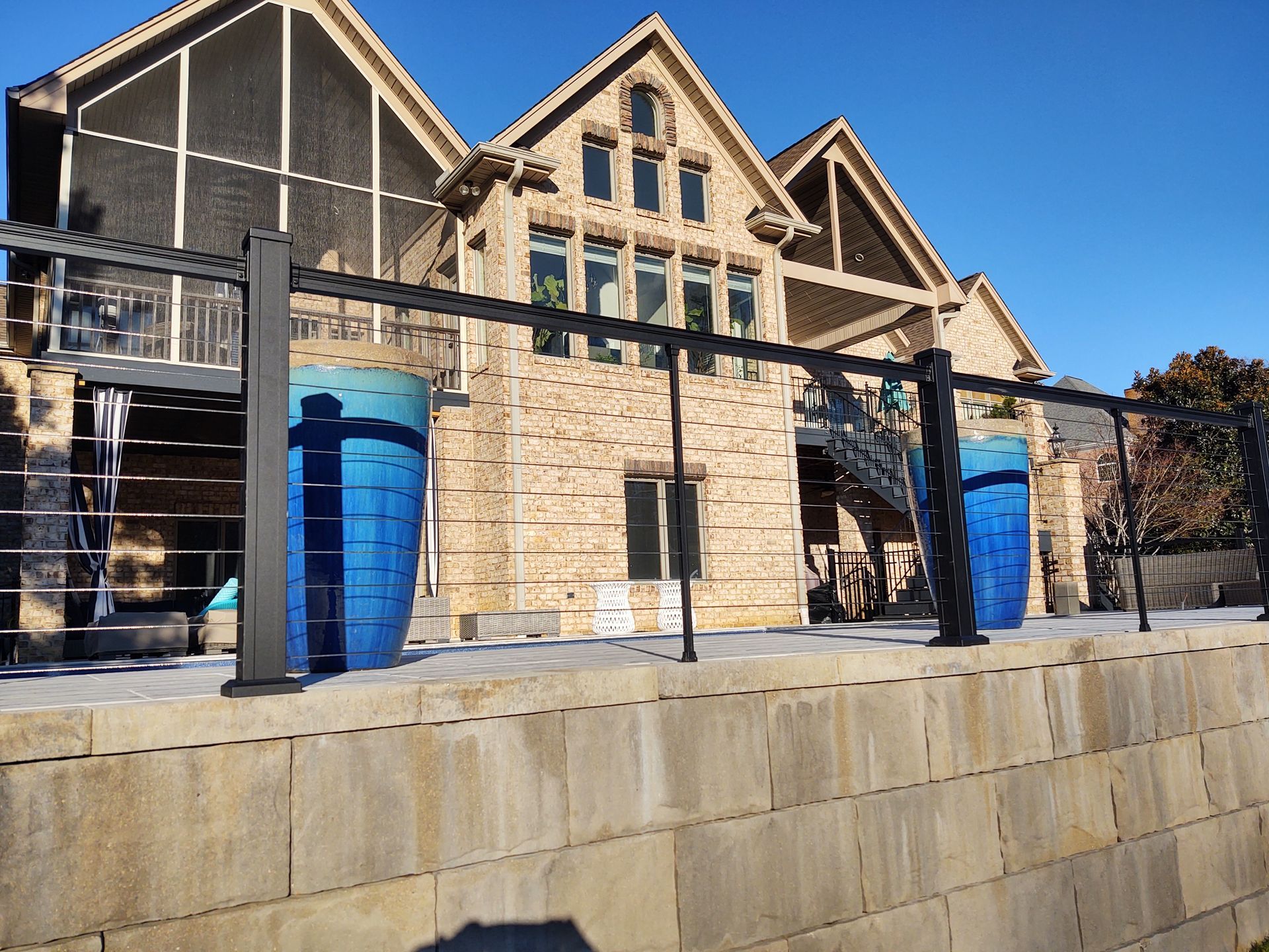 A large house with a fence around it and two blue vases in front of it