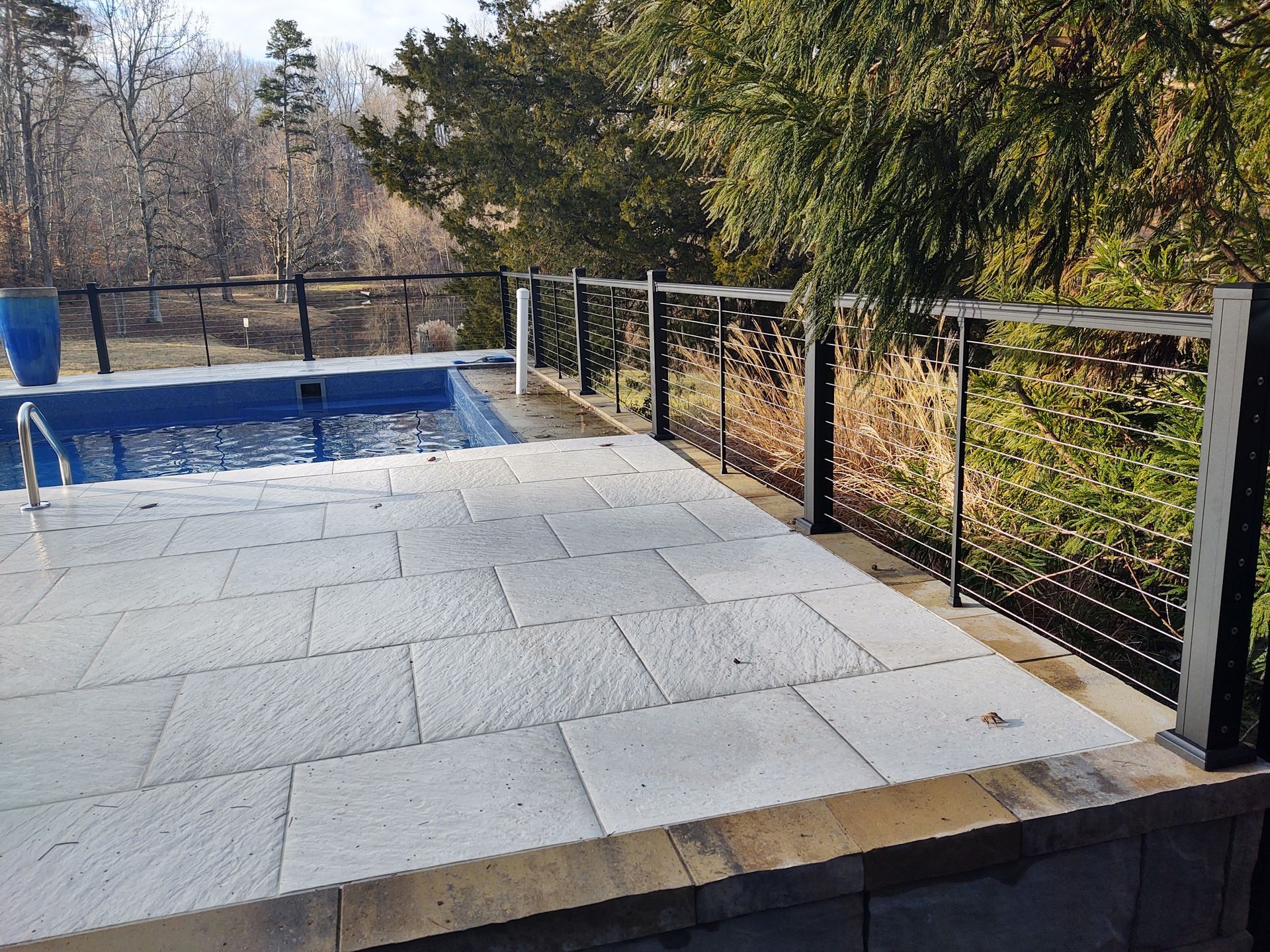 A swimming pool with a fence around it and trees in the background