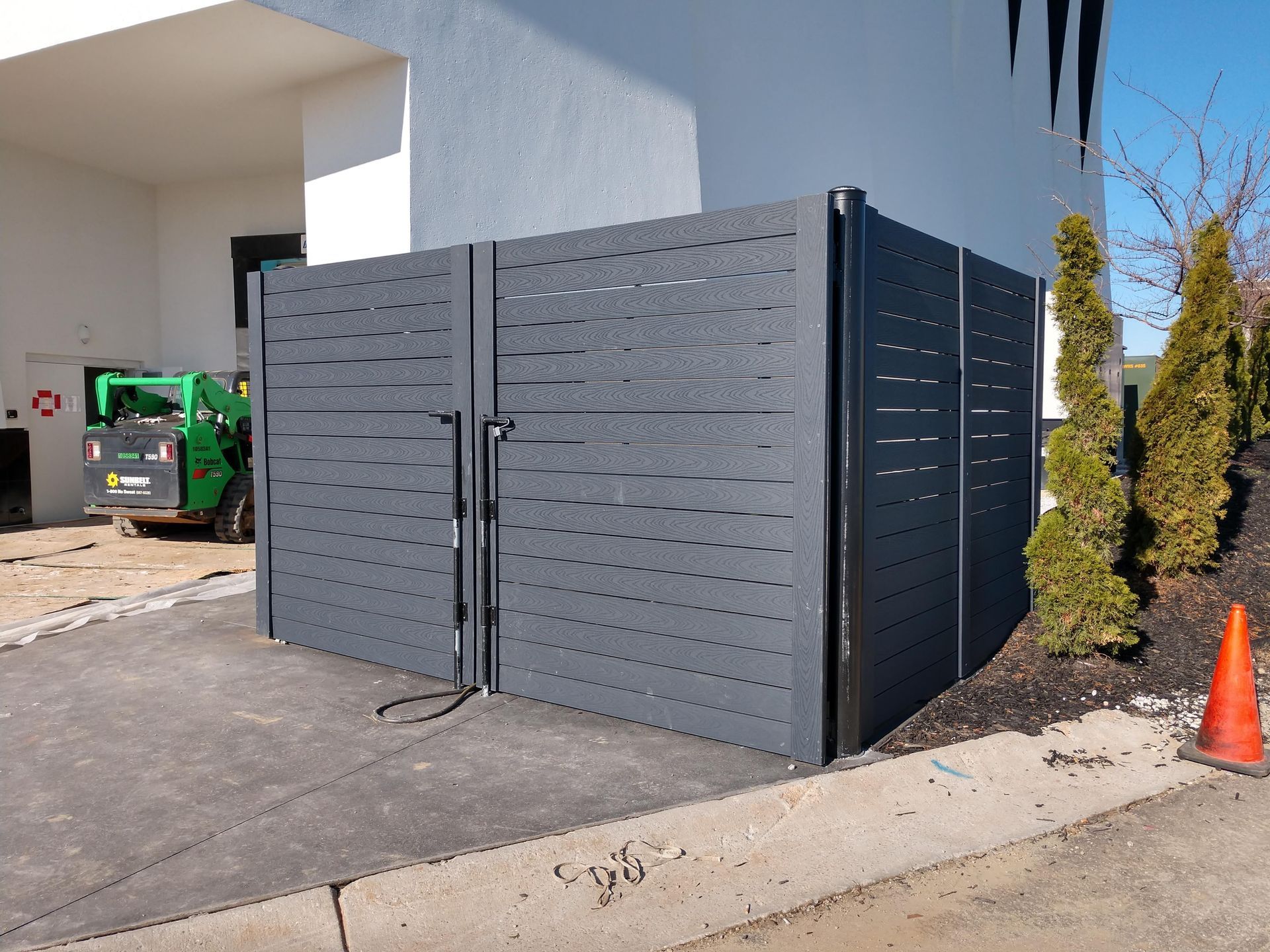 a fence with holes in it is in front of a building