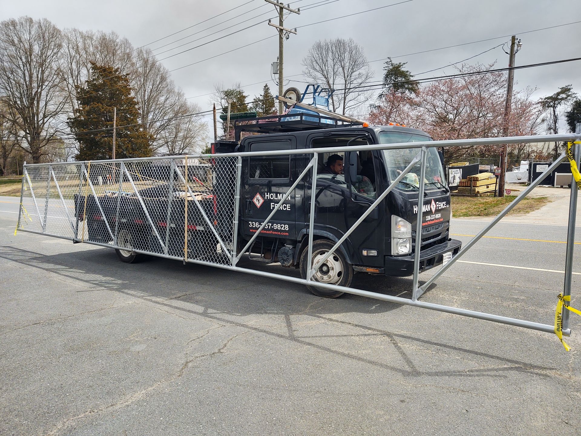 a truck driving through a fence on the side of the road