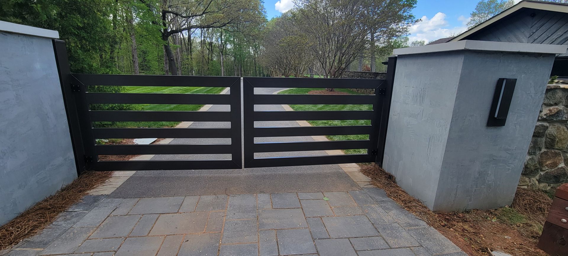 A black gate in the middle of a driveway