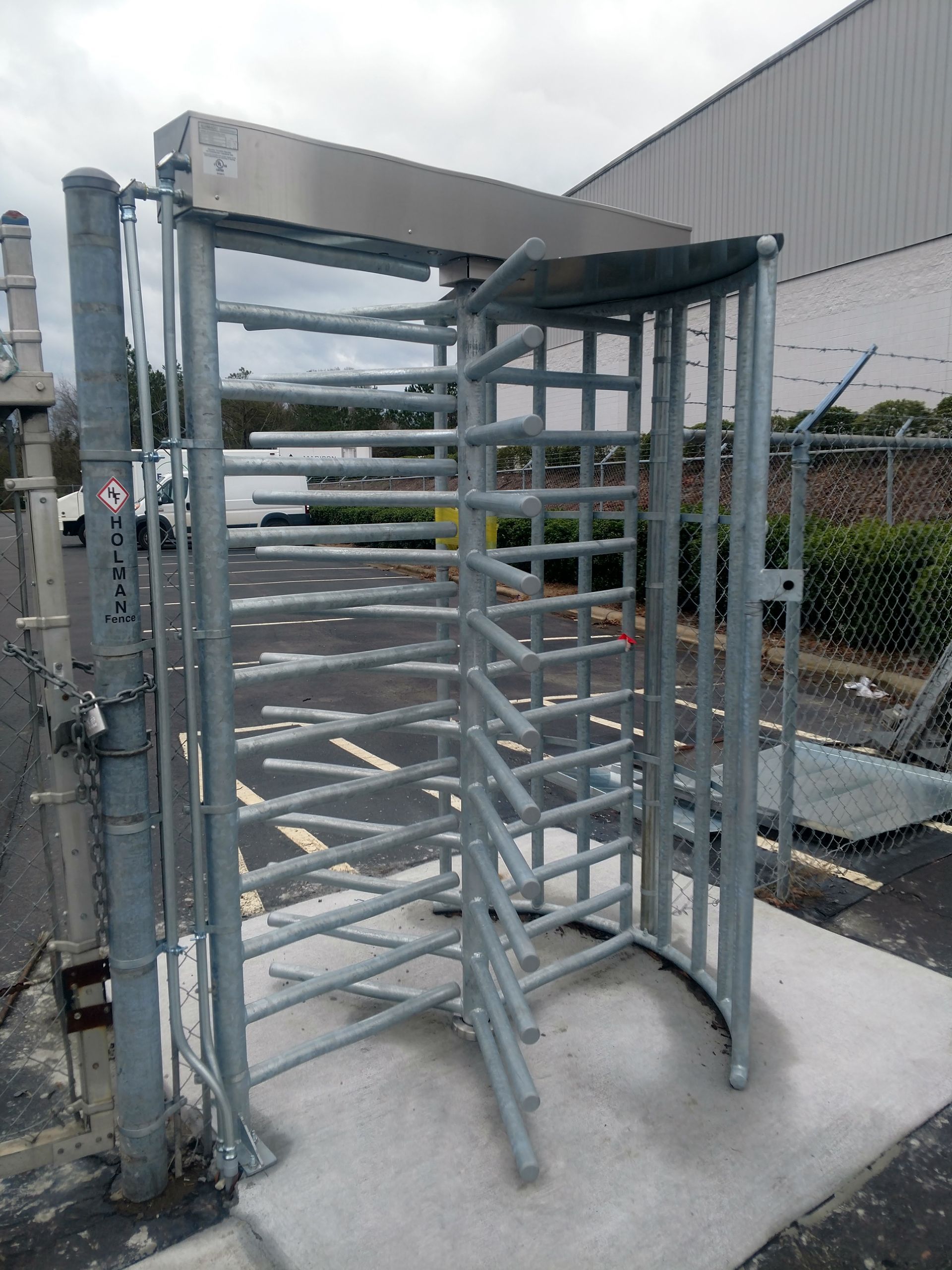 a metal turnstile sitting on a concrete platform in front of a building