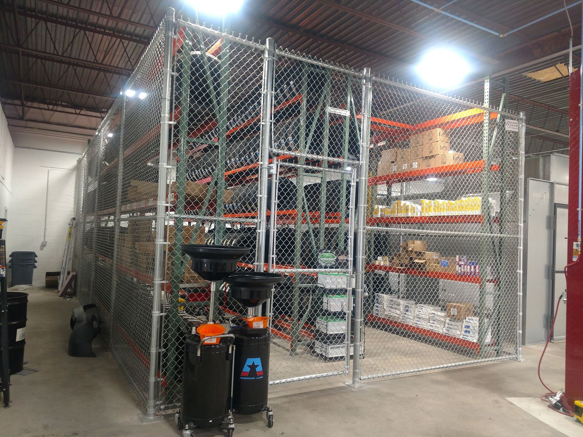 a warehouse with lots of shelves and a chain link fence