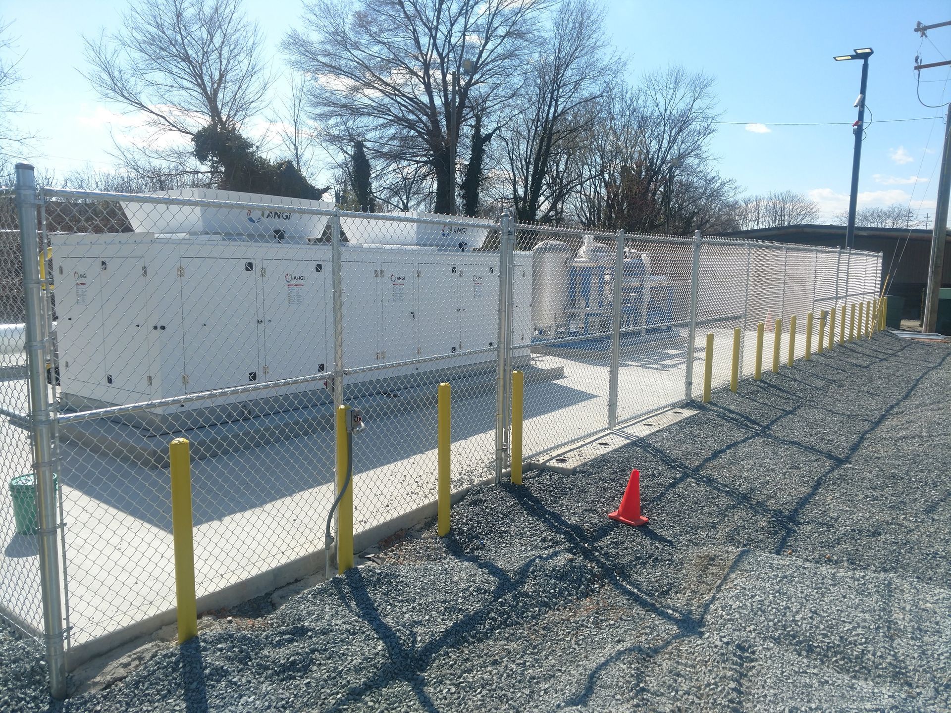 a chain link fence surrounds a large white container