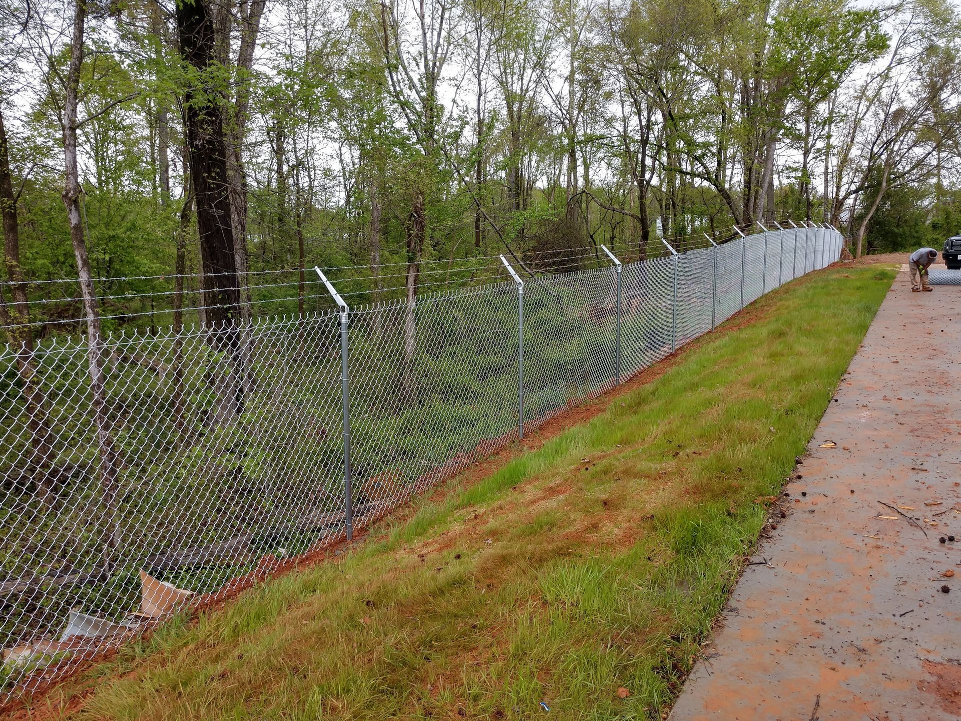 a chain link fence being built on the side of a road