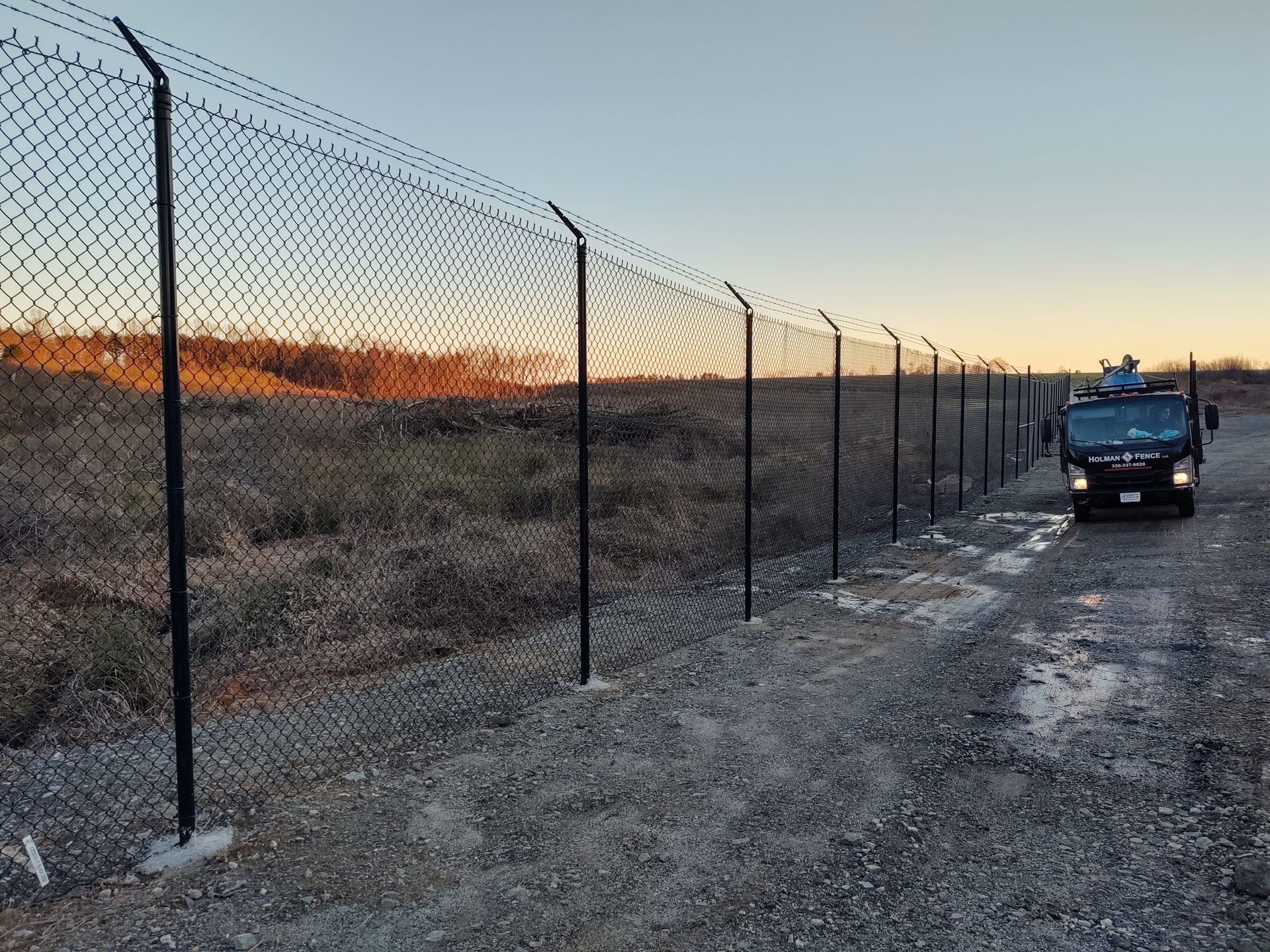 a black van parked next to a chain link fence