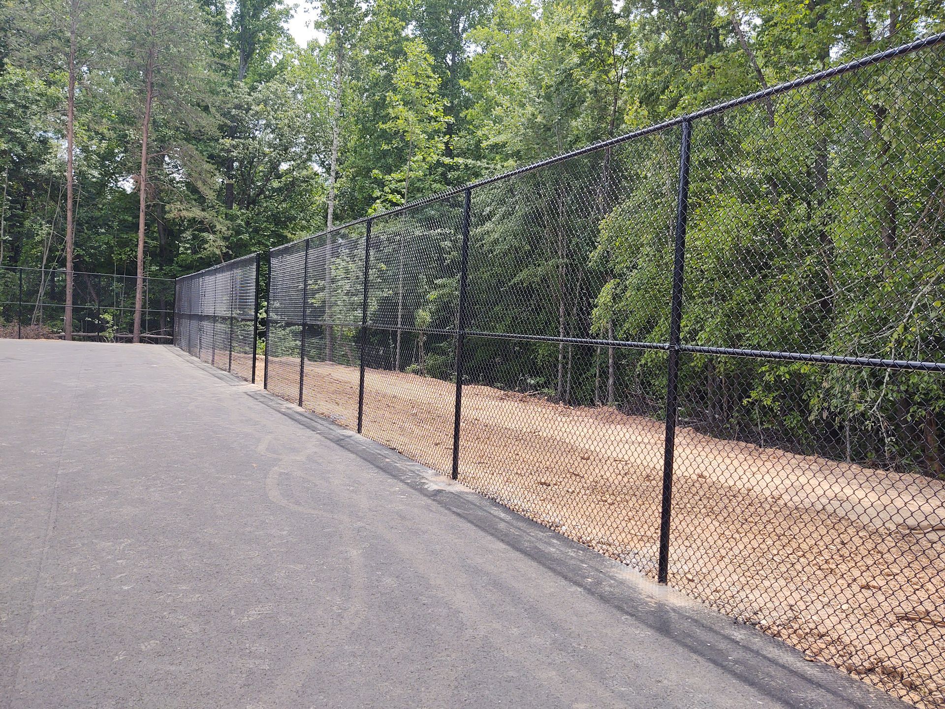 a chain link fence along the side of a road