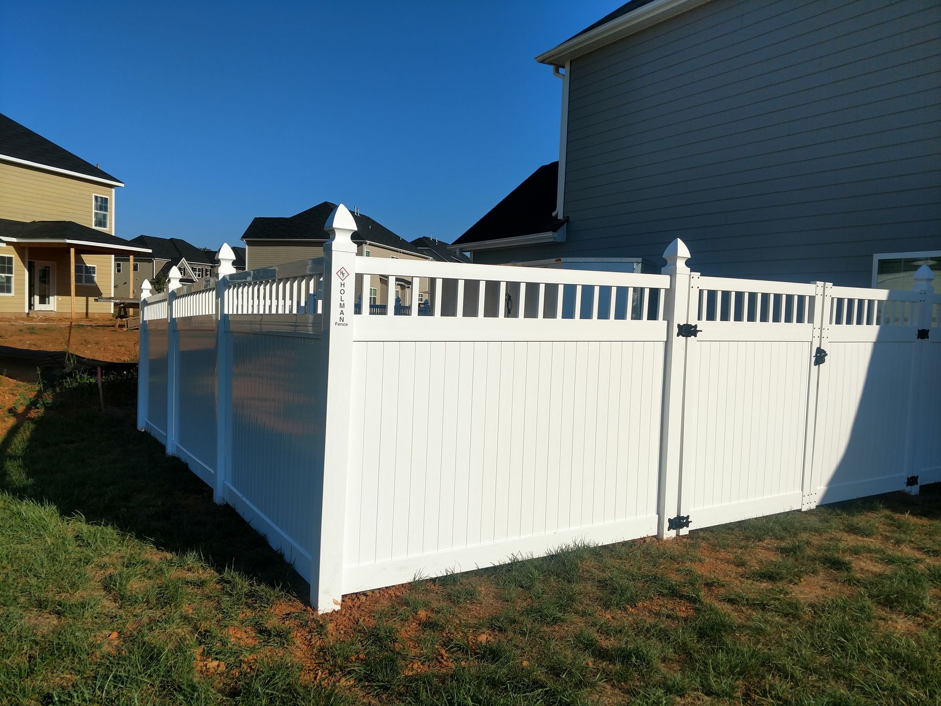 a white fence in the backyard of a house