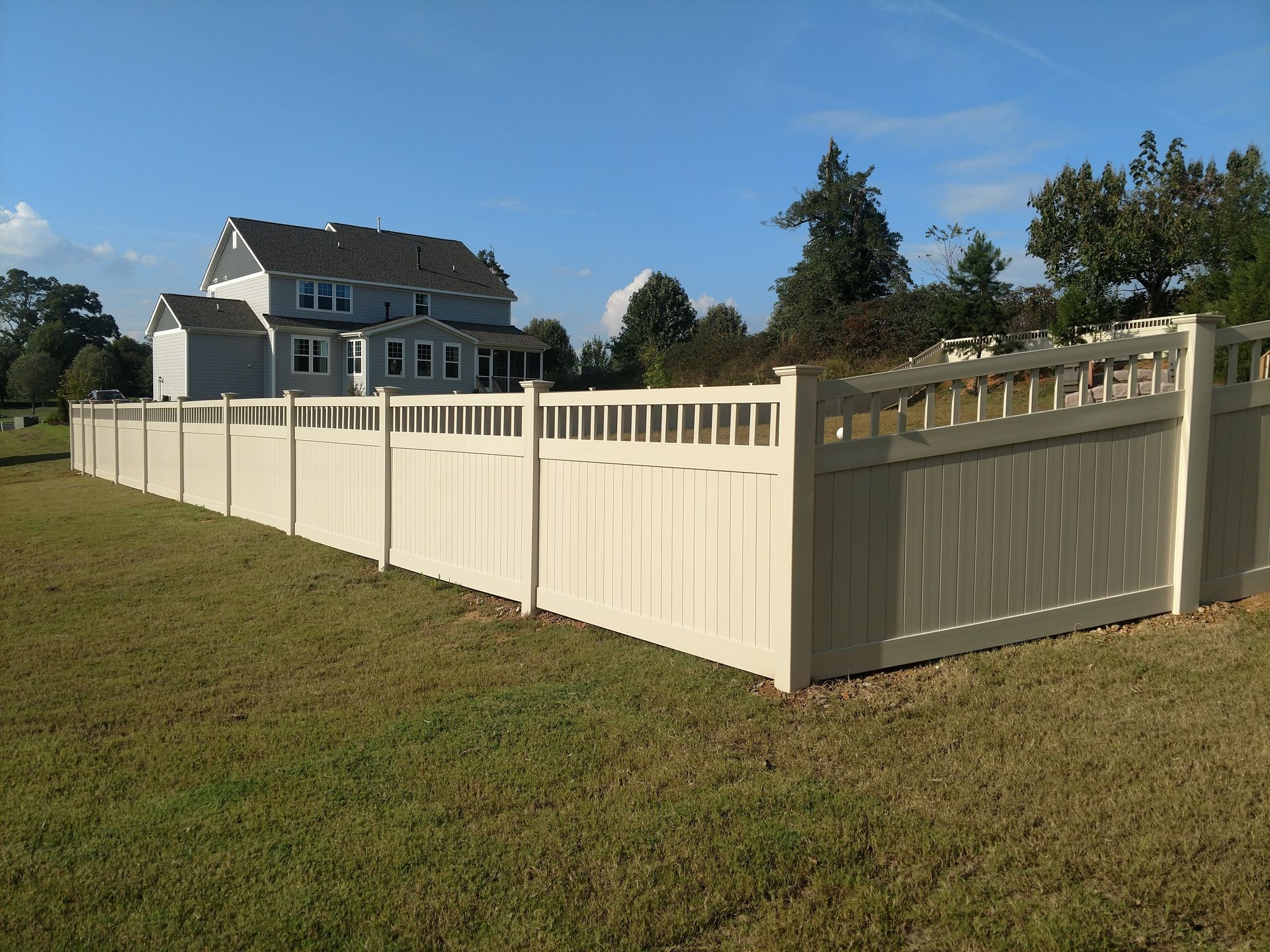 a white fence with a house in the background