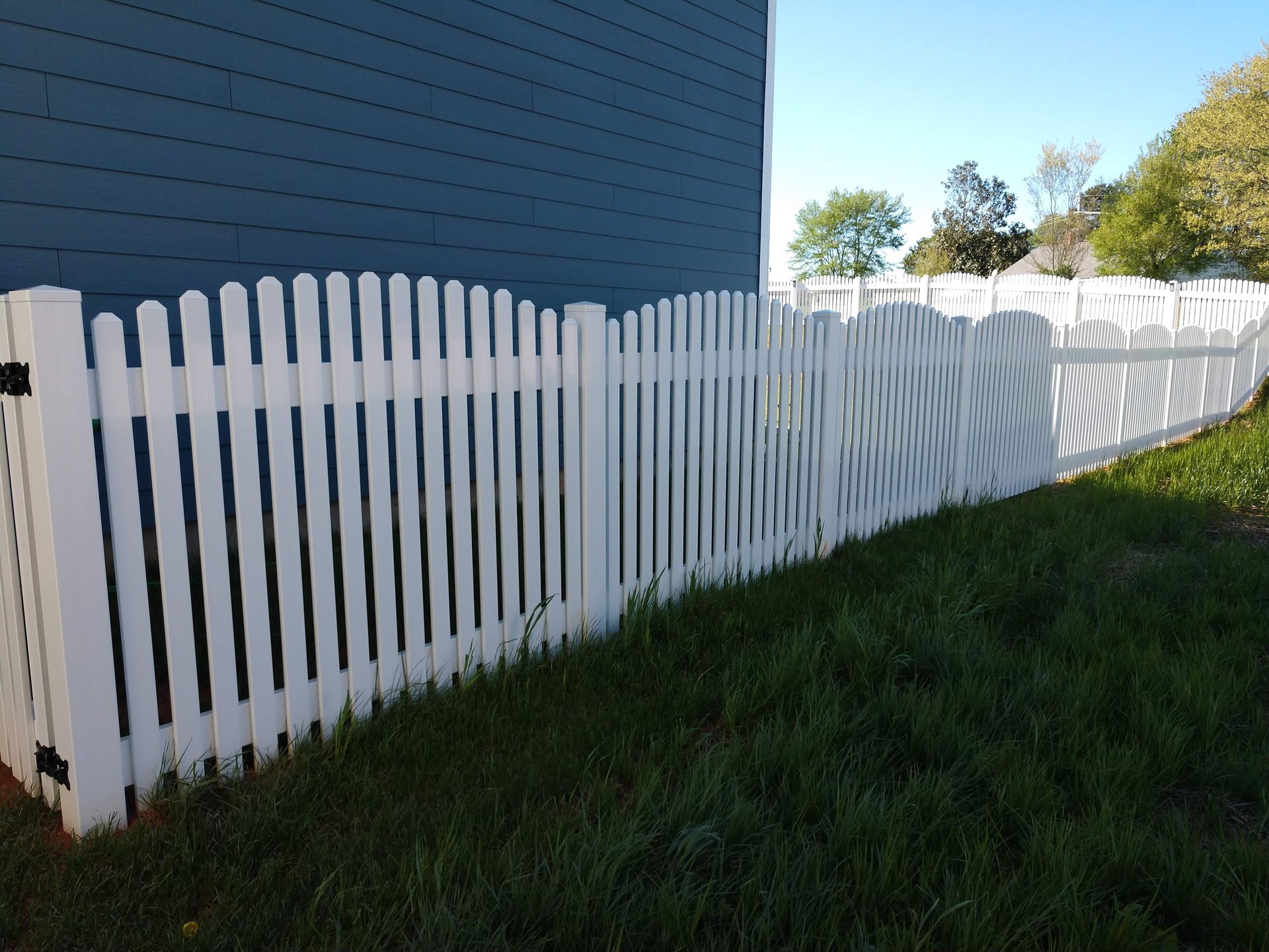 a white picket fence in front of a blue house