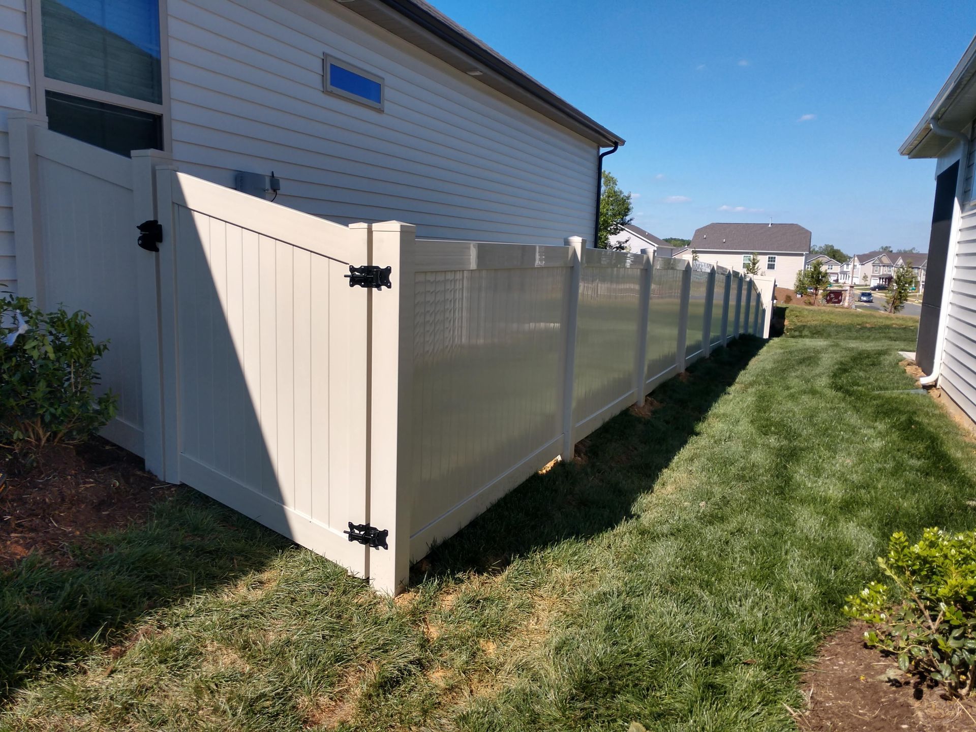 a white fence surrounds a lush green yard in front of a house