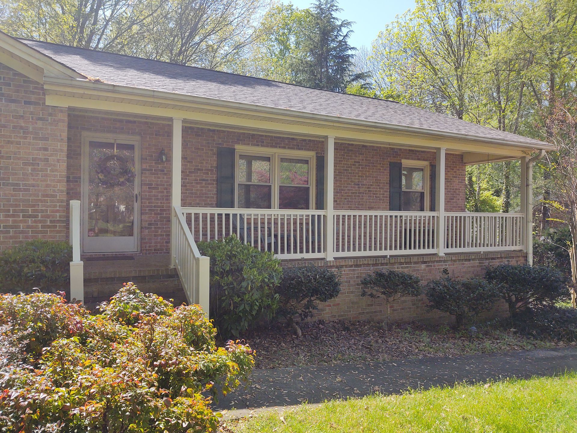 a brick house with a porch and a white railing