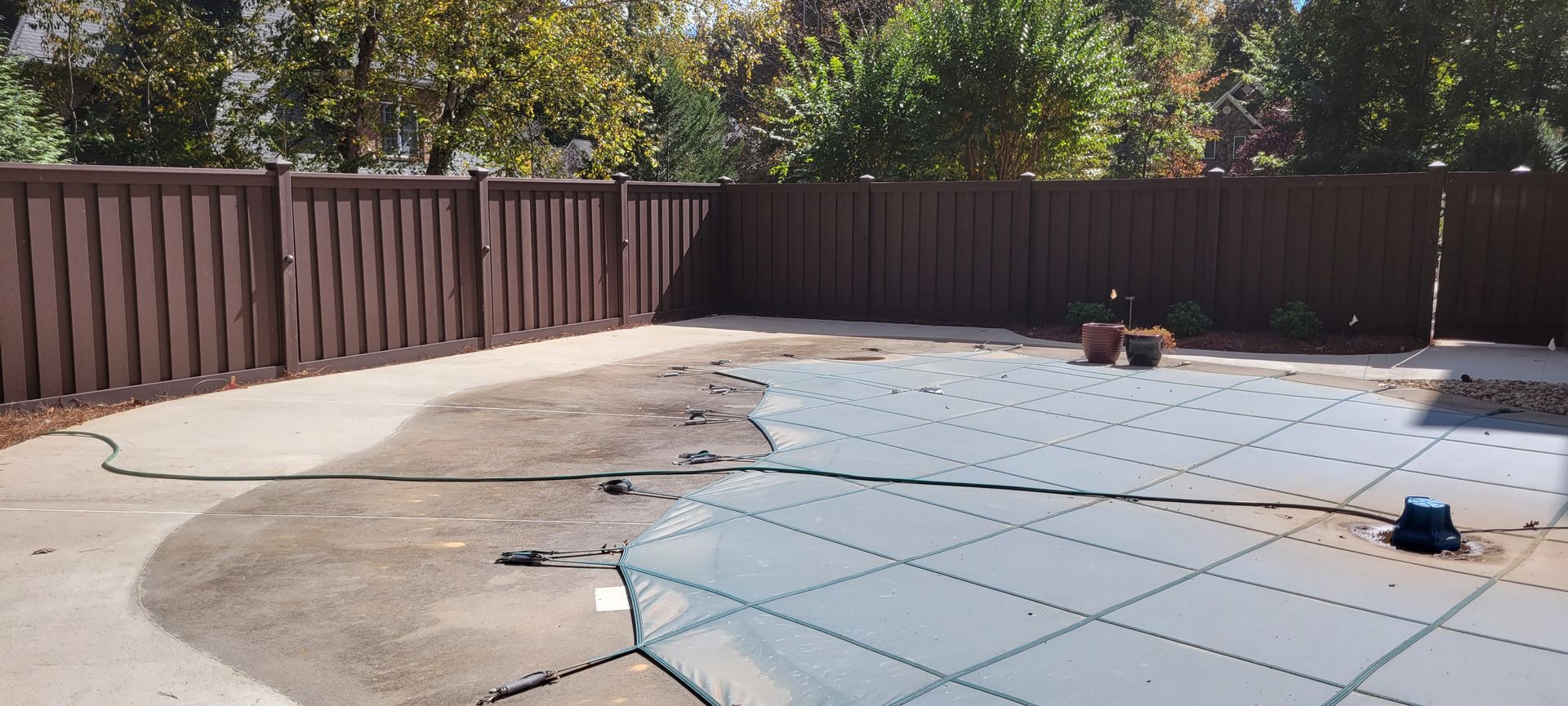 a fence surrounds a swimming pool with a cover on it