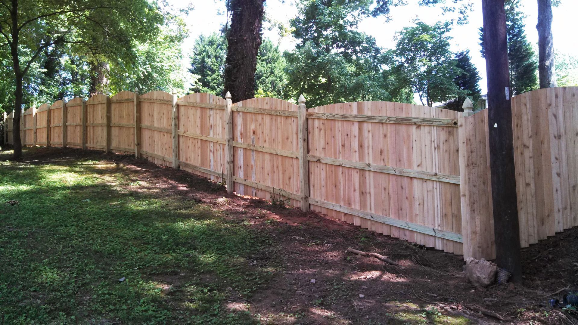 a wooden fence surrounded by trees and grass