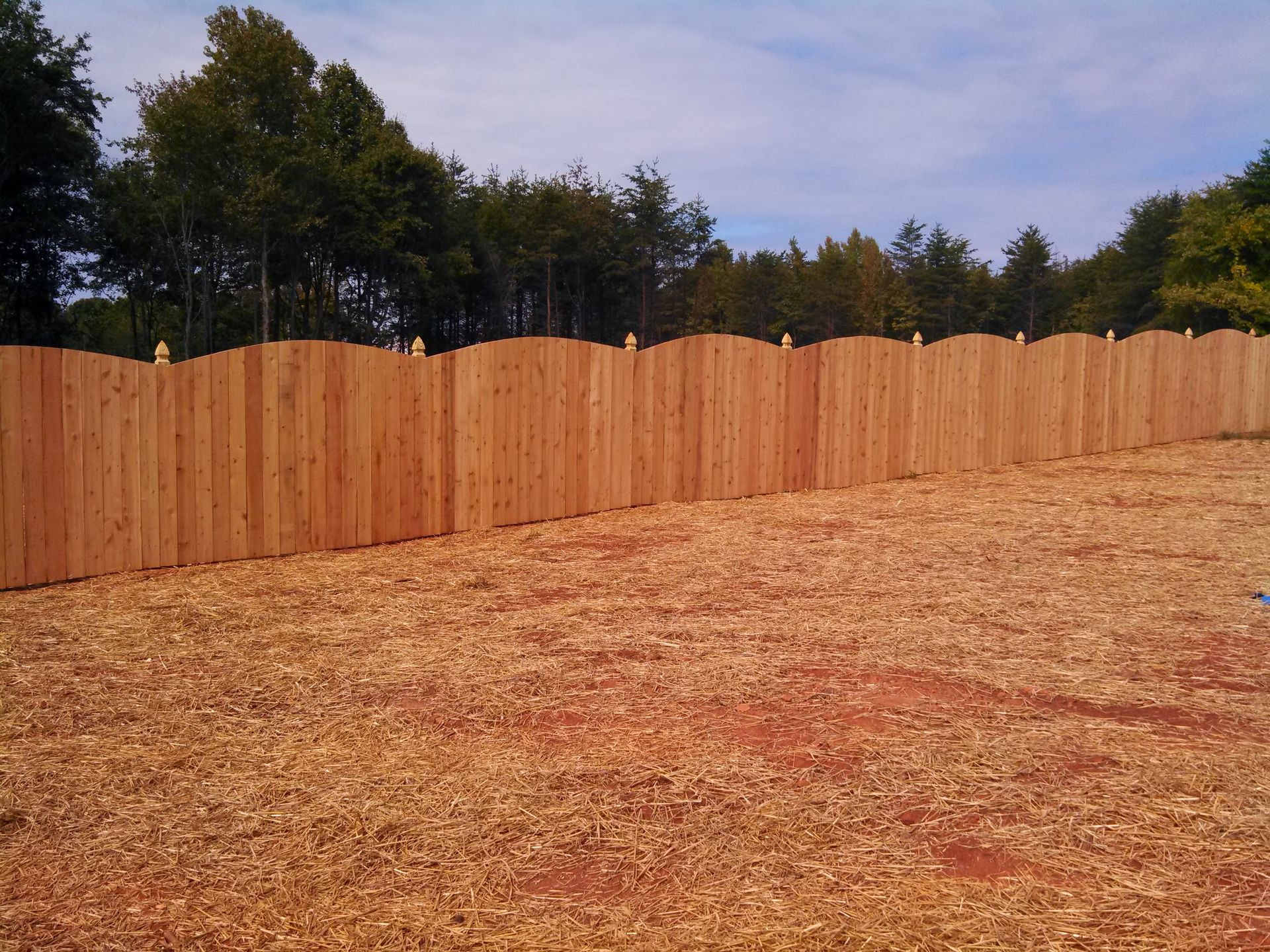 a wooden fence surrounds a pile of wood chips