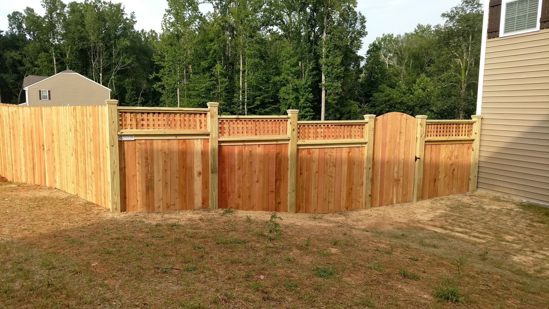 a wooden fence with a gate in the backyard of a house