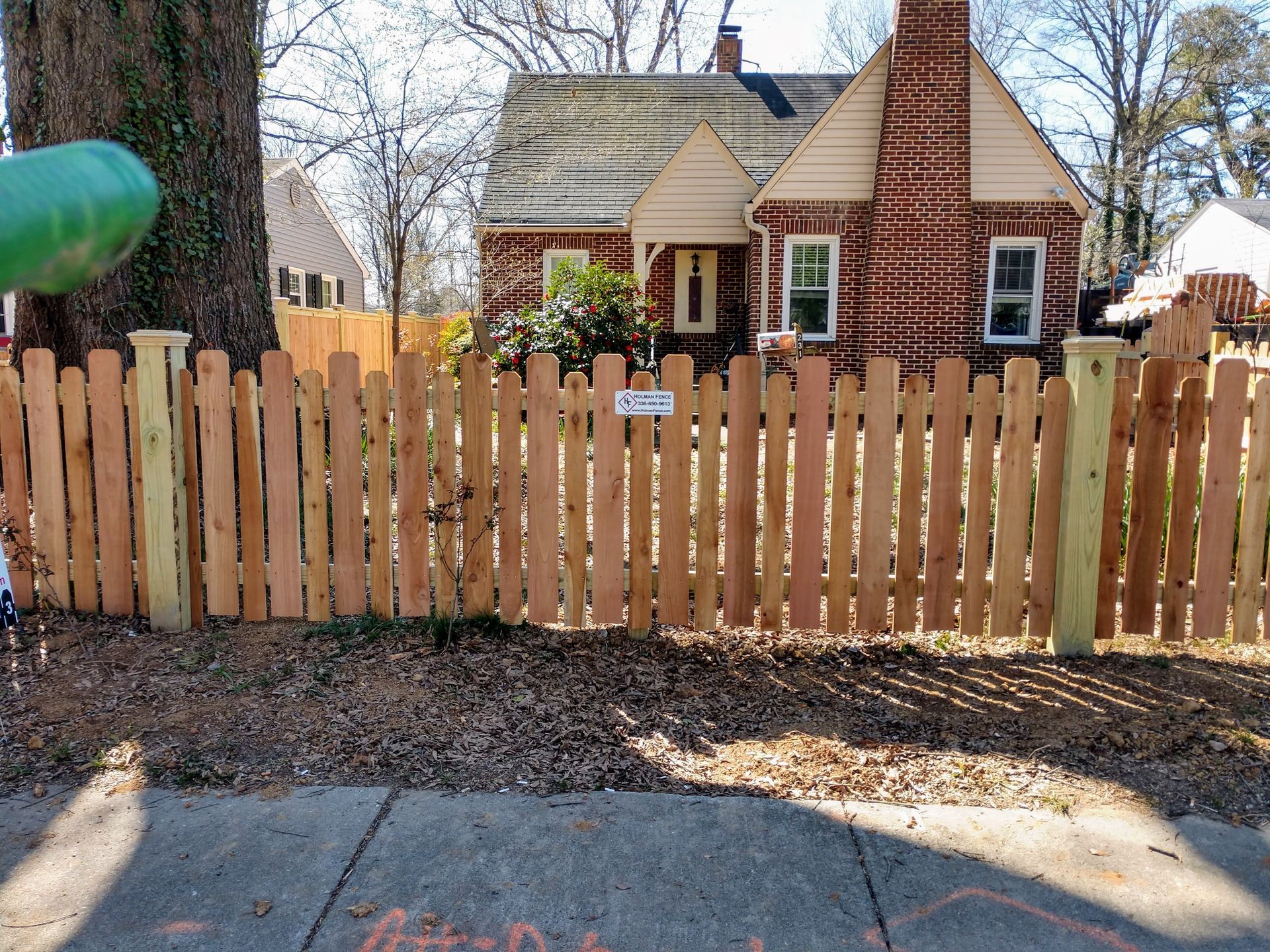 a wooden fence in front of a brick house