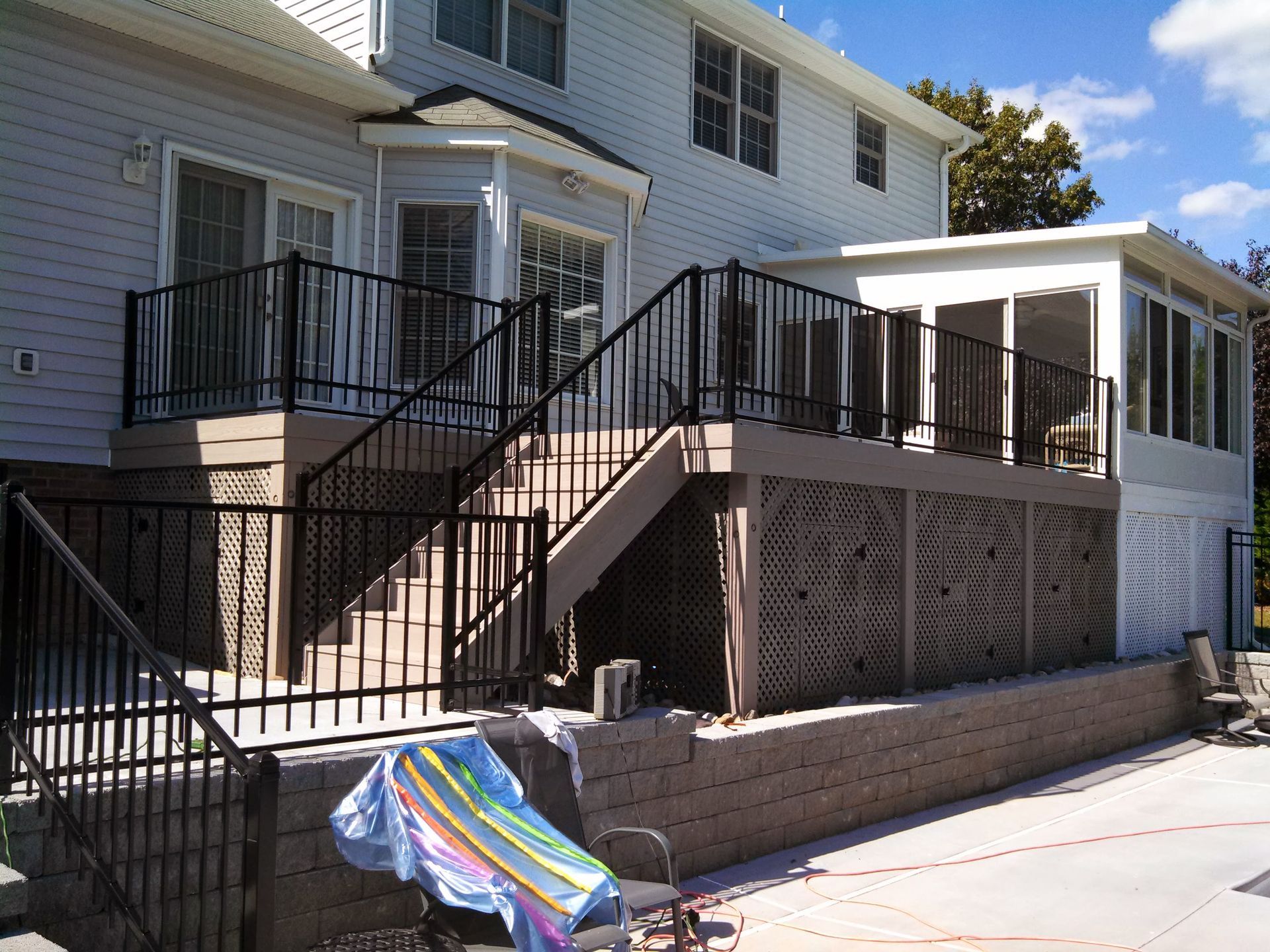 A white house with a black railing and stairs