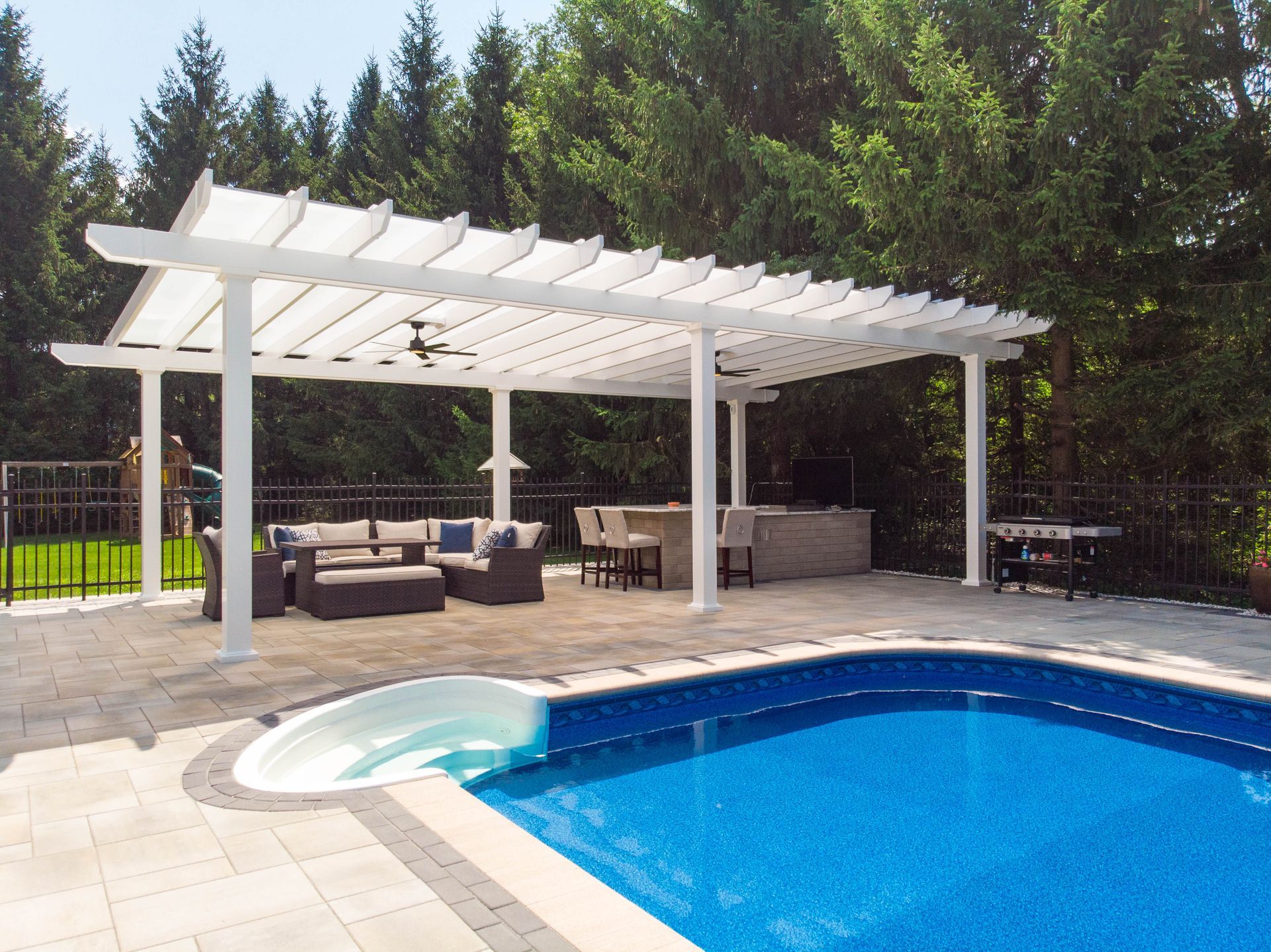 A backyard swimming pool with a white pergola covering a patio featuring lounge furniture and a hot tub.