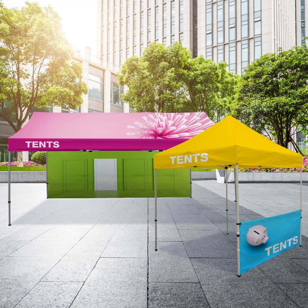 A pink tent is sitting next to a green tent and a yellow tent.
