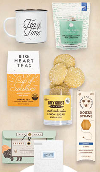 A table topped with a mug , cookies , candles , and other items.