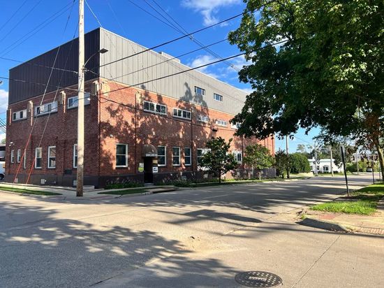 A large brick building is sitting on the corner of a street.