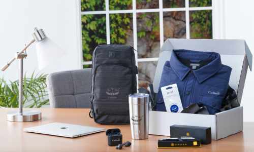 A box filled with a variety of items is sitting on a wooden table.