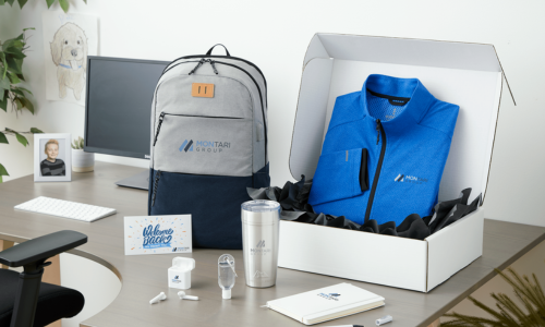 A desk with a backpack , jacket , cup , and other items on it.