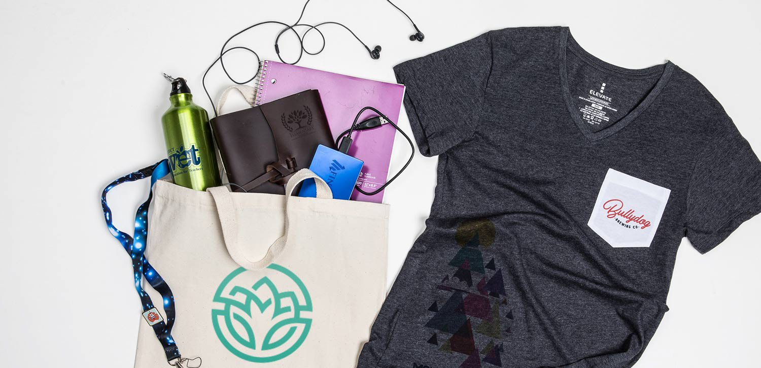 A tote bag filled with a variety of items and a t-shirt.