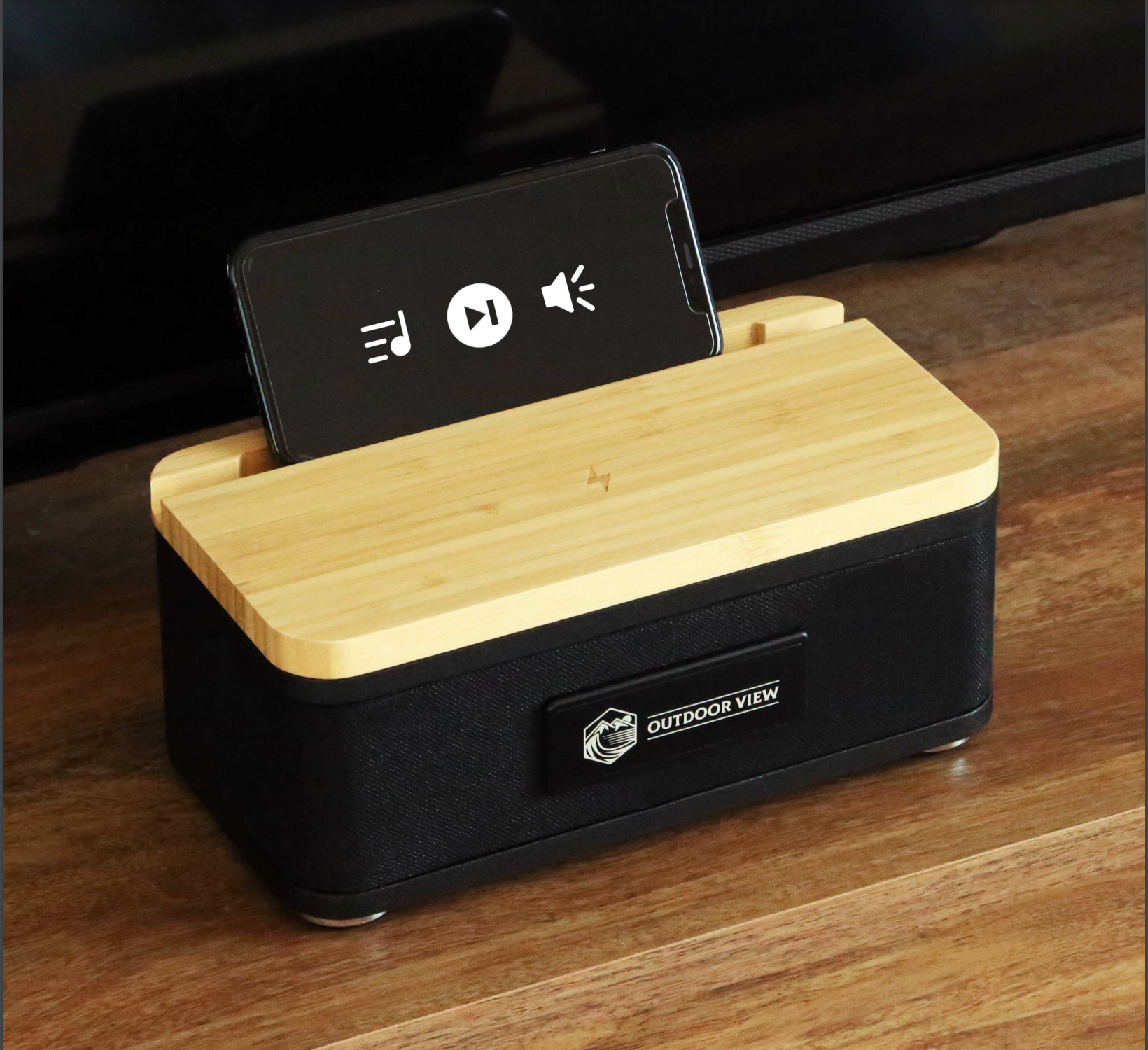 A phone is sitting on top of a wooden box on a wooden table