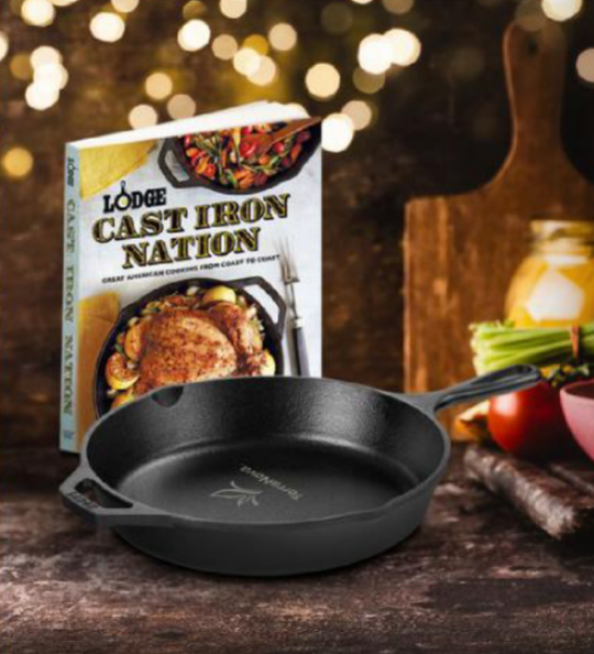 A cast iron skillet next to a book titled cast iron nation