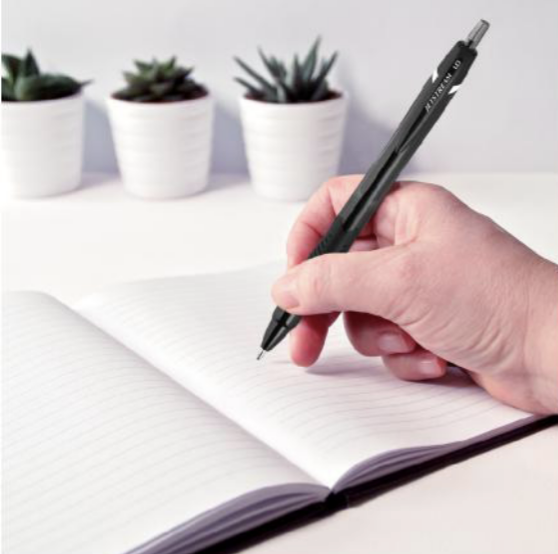 A person is writing in a notebook with a pen