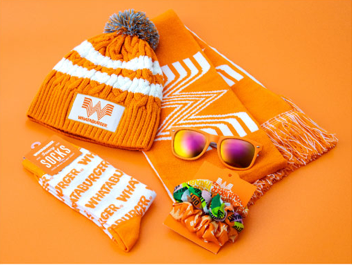 A hat , scarf , socks , sunglasses and a candy bar are all orange.