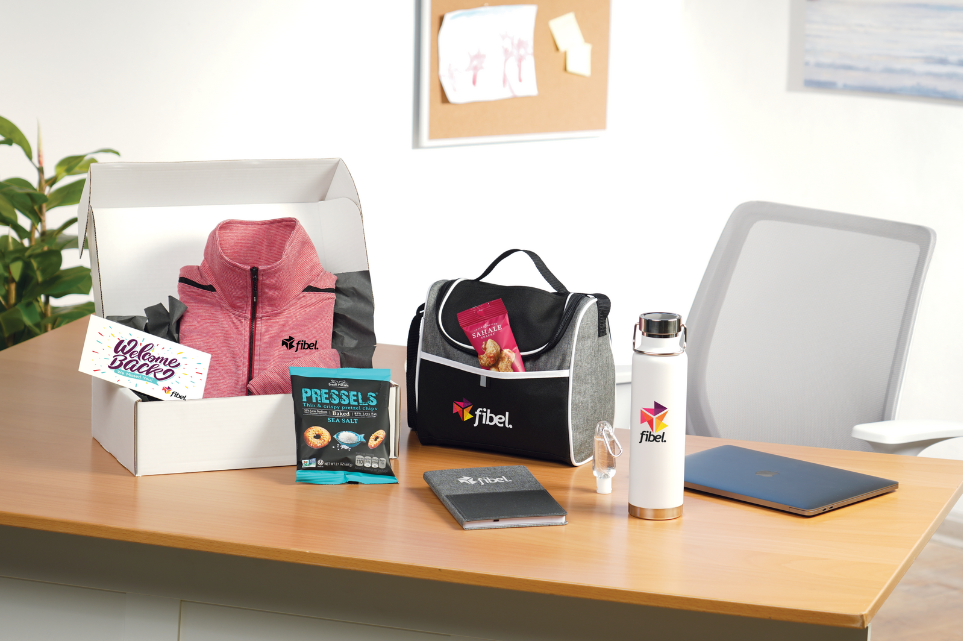 A desk with a box , a lunch bag , a water bottle , a notebook , and other items on it.