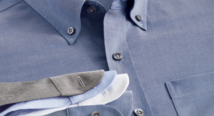 A close up of a blue shirt with a tie on top of it.