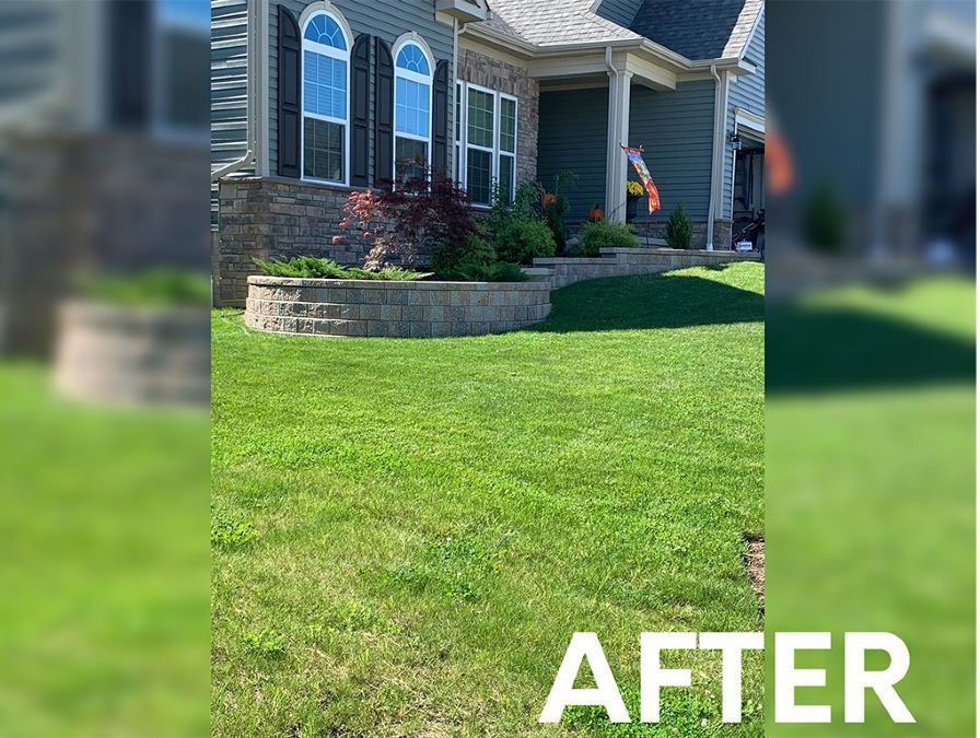 A house exterior with a freshly landscaped stone retaining wall and green lawn, labeled 