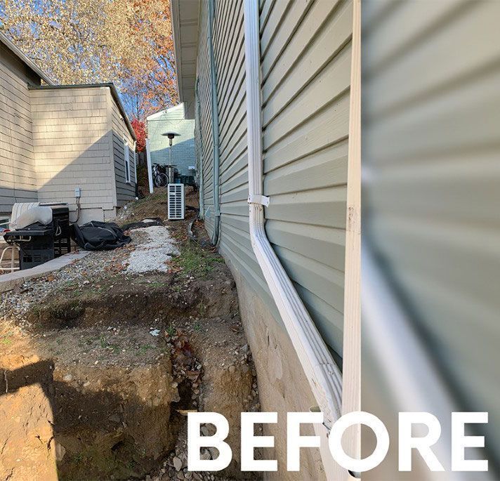 Side yard with a partially excavated dirt slope next to a house exterior, labeled 